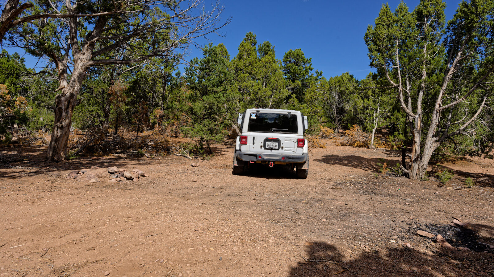 Camping spot for one or two small rigs or small trailers. It has shade but is not private, and it sits next to an ATV trail.