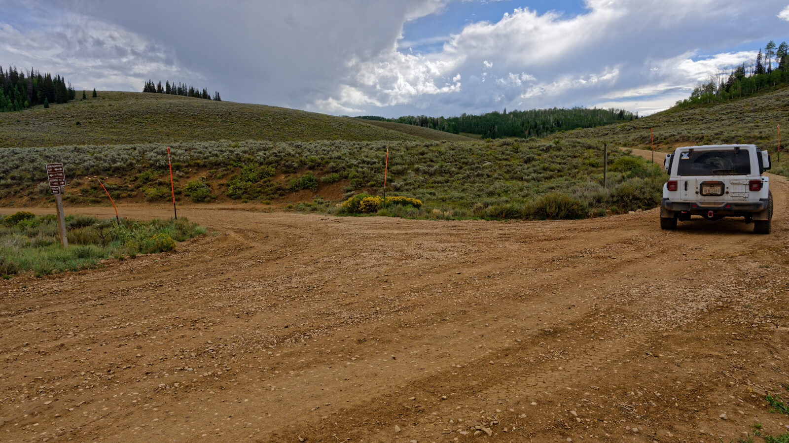 Hilltop camping area with room for four to six rigs, no shade and little privacy, close to power lines. Two smaller spots just off the road hold one or two rigs each. The road up from the main road is a bit harder, so a trailer may struggle.