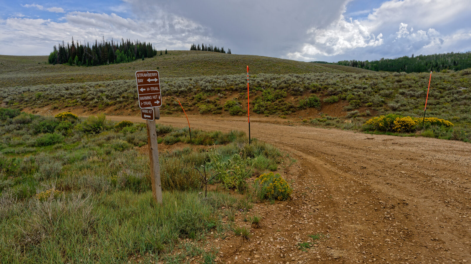 Hilltop camping area with room for four to six rigs, no shade and little privacy, close to power lines. Two smaller spots just off the road hold one or two rigs each. The road up from the main road is a bit harder, so a trailer may struggle.