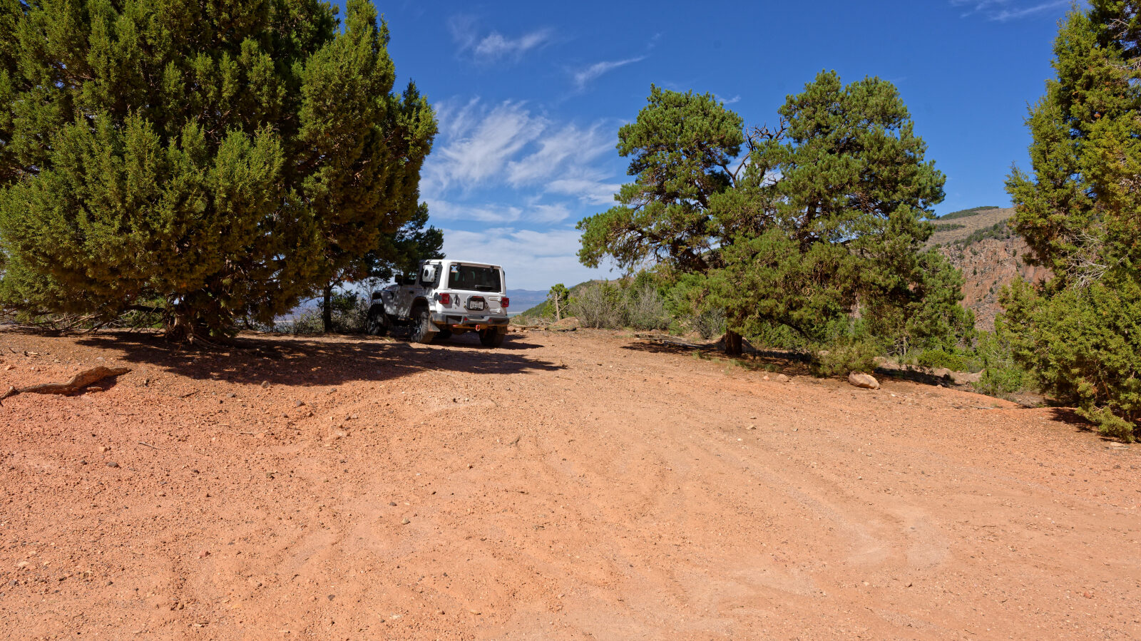 Campsite fits one rig, maybe one trailer. It is close to the road with no privacy, some afternoon shade and a view.